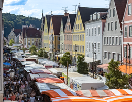 Farbenfrohe Häuserfassaden, Altstadt gefüllt mit Menschen und Marktständen