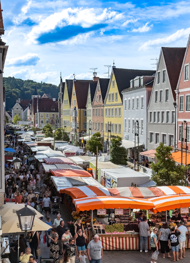 Farbenfrohe Häuserfassaden, Altstadt gefüllt mit Menschen und Marktständen
